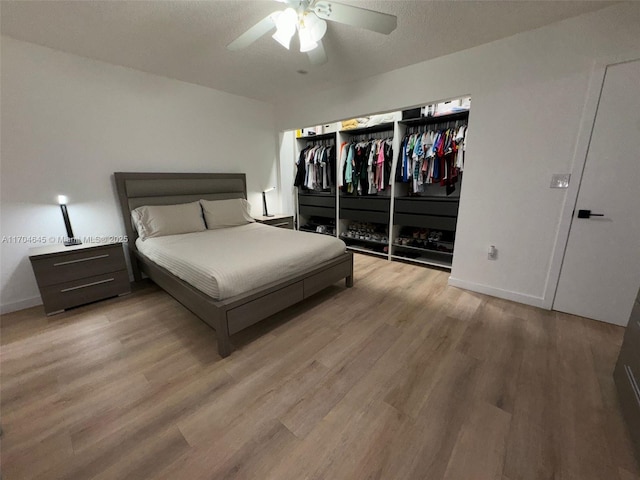 bedroom with ceiling fan, a closet, and light hardwood / wood-style flooring