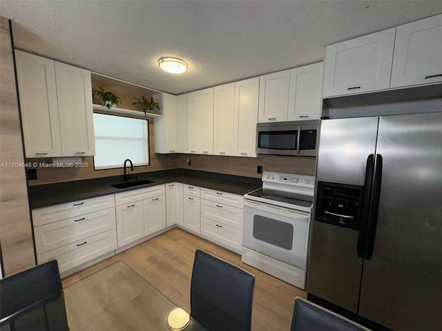 kitchen featuring white cabinets, light hardwood / wood-style floors, sink, and stainless steel appliances