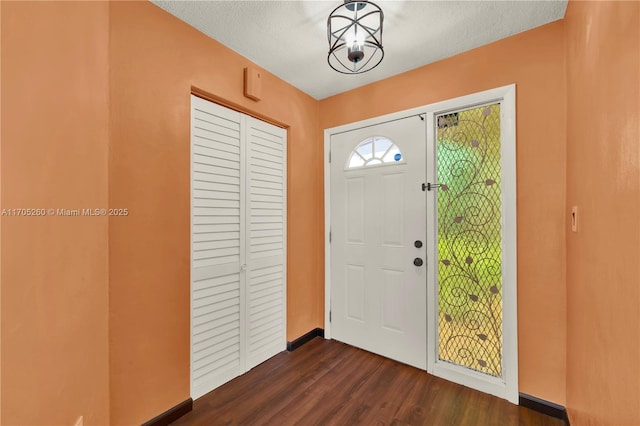 entrance foyer featuring a textured ceiling and dark wood-style flooring