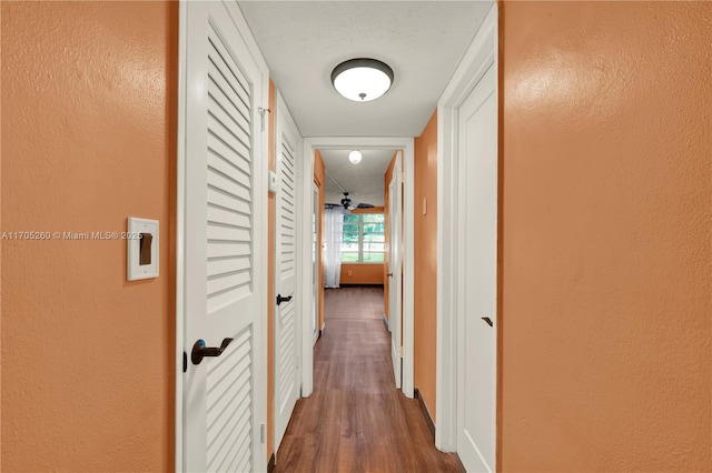 corridor featuring a textured wall and wood finished floors