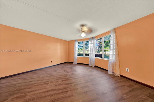 unfurnished room with ceiling fan, baseboards, and dark wood finished floors