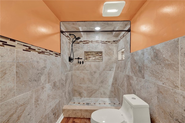 bathroom with toilet, a stall shower, and tile walls