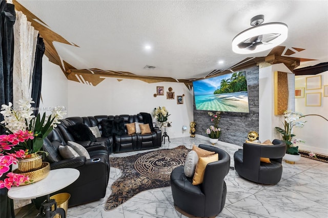 living room with ceiling fan and a textured ceiling