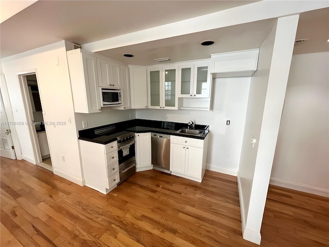 kitchen featuring stainless steel appliances, sink, white cabinets, and light wood-type flooring