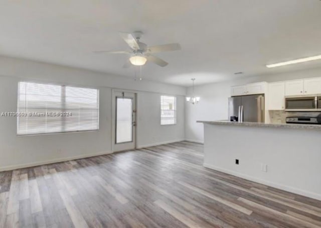 kitchen featuring ceiling fan with notable chandelier, stainless steel appliances, white cabinetry, and hardwood / wood-style flooring