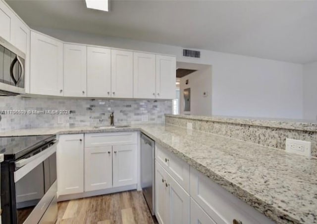 kitchen featuring stainless steel appliances, white cabinetry, and sink