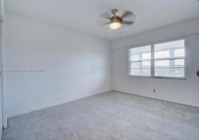 spare room with ceiling fan and light carpet