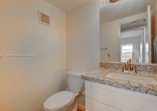 bathroom featuring vanity and toilet