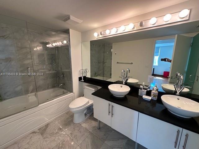 31 SE 5th St Unit 1908, Miami, FL 33131 - full bathroom featuring marble look tiles, bath / shower combo with glass door, and double vanity