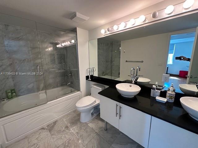 31 SE 5th St Unit 1908, Miami, FL 33131 - full bathroom featuring bath / shower combo with glass door, marble look tile flooring, and double vanity