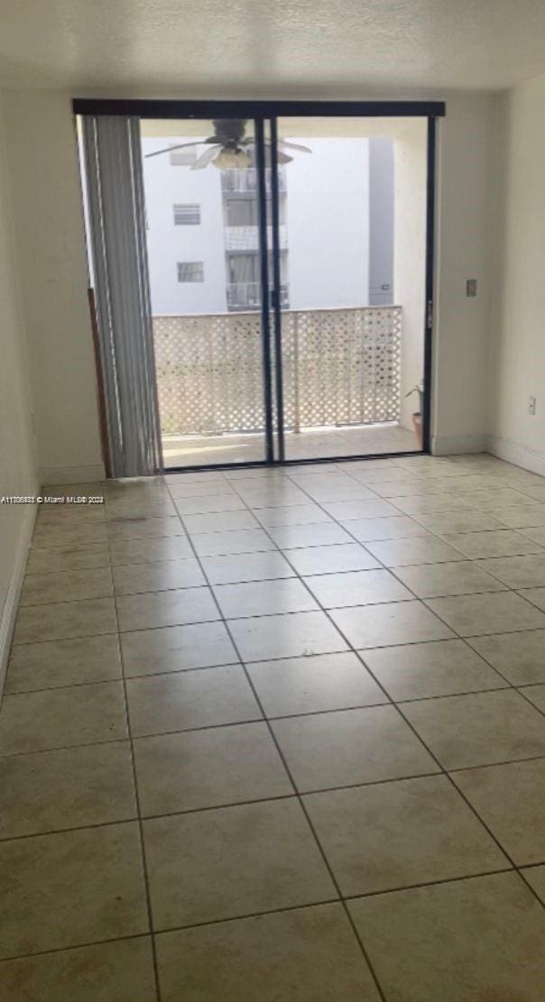 tiled spare room featuring ceiling fan