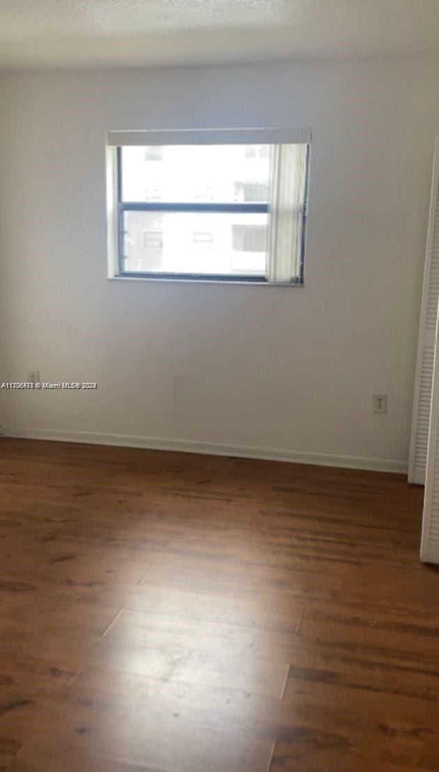 unfurnished room with dark hardwood / wood-style floors