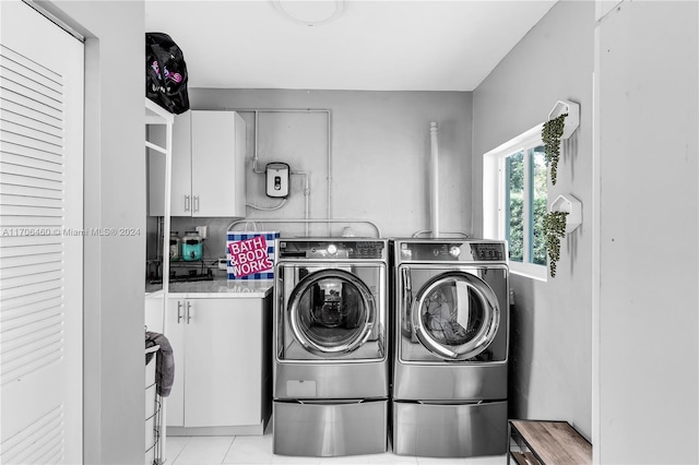 laundry room with light tile patterned floors, cabinets, and independent washer and dryer