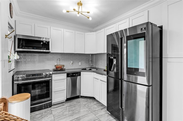 kitchen with a chandelier, appliances with stainless steel finishes, white cabinetry, and sink