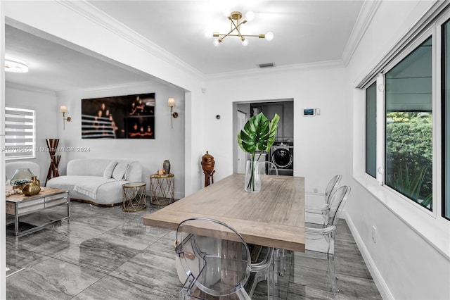 dining space with washer / clothes dryer, crown molding, and a notable chandelier