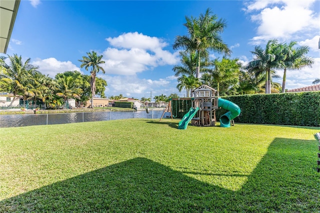 view of play area with a yard and a water view