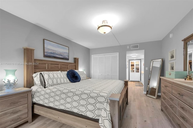 bedroom with light hardwood / wood-style flooring and a closet