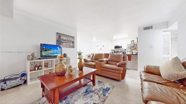 kitchen with kitchen peninsula, appliances with stainless steel finishes, sink, light tile patterned flooring, and a breakfast bar