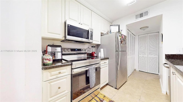 kitchen with stainless steel appliances, white cabinets, visible vents, and light tile patterned floors