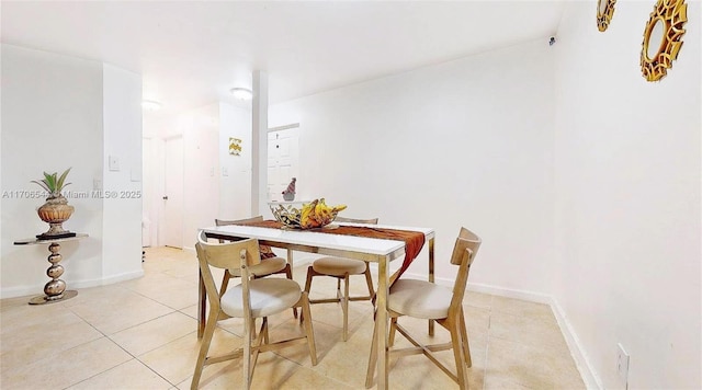 dining area featuring light tile patterned floors and baseboards