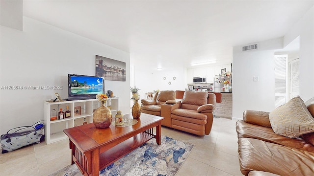 living room with light tile patterned flooring and visible vents