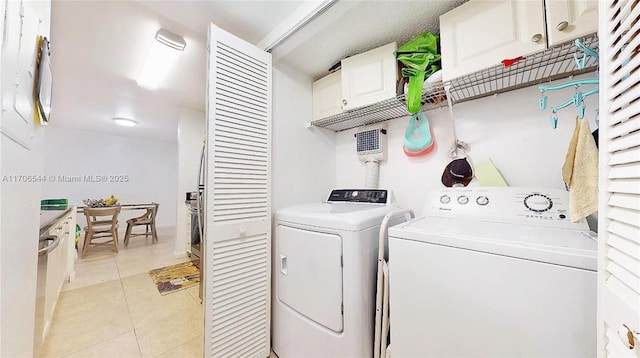 laundry area featuring light tile patterned floors, laundry area, and separate washer and dryer