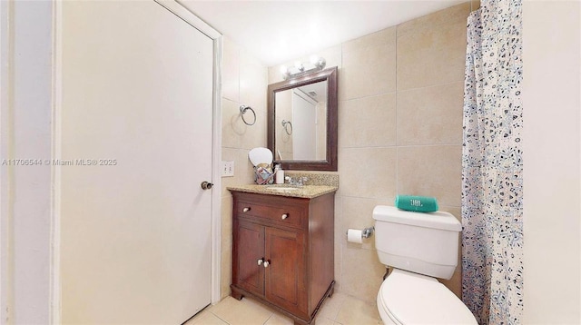 full bath featuring tile patterned flooring, tile walls, toilet, and vanity