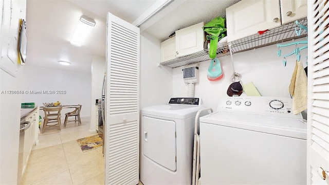 laundry room featuring light tile patterned floors, laundry area, and washer and clothes dryer