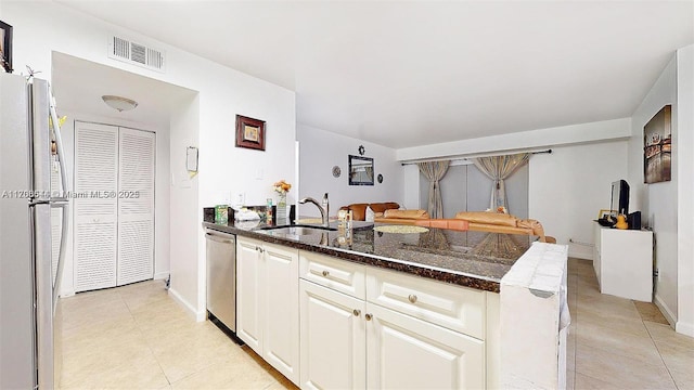 kitchen featuring a sink, visible vents, white cabinetry, appliances with stainless steel finishes, and dark stone countertops