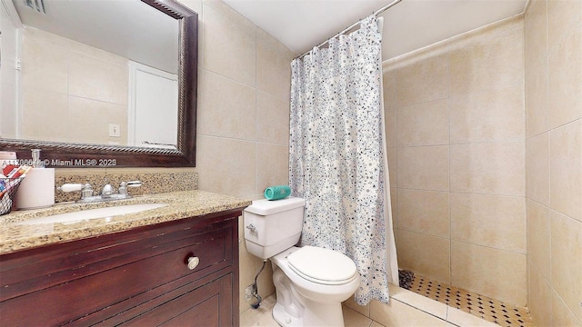 full bath featuring toilet, a shower stall, tile walls, and vanity