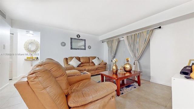 living area featuring baseboards and light tile patterned floors