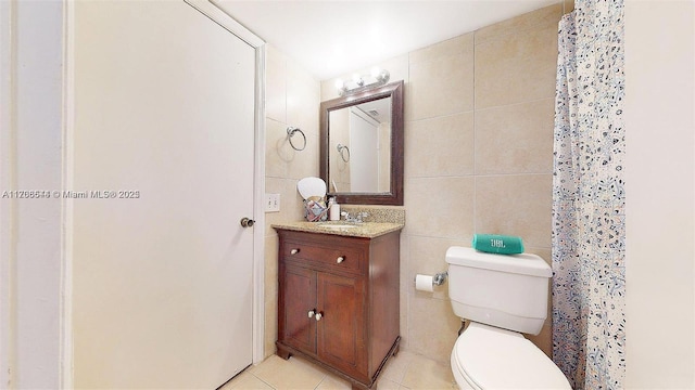 full bath with toilet, vanity, tile walls, and tile patterned floors