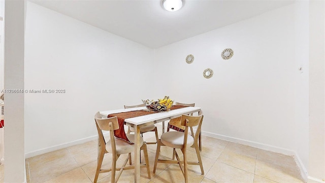 dining space with light tile patterned flooring and baseboards