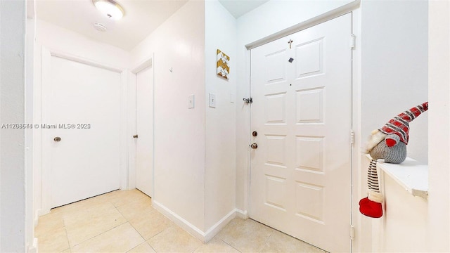 foyer featuring light tile patterned floors and baseboards