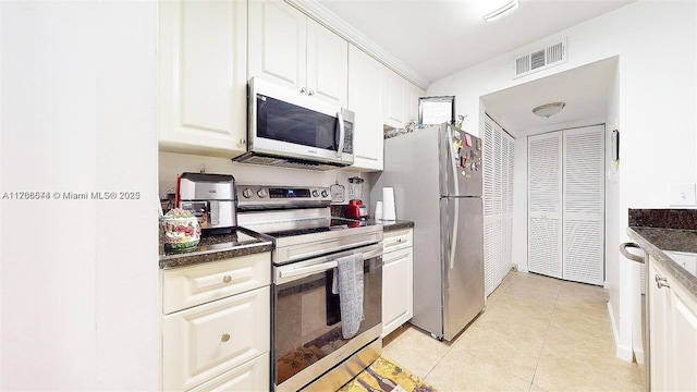 kitchen featuring light tile patterned floors, visible vents, white cabinets, dark stone counters, and stainless steel appliances