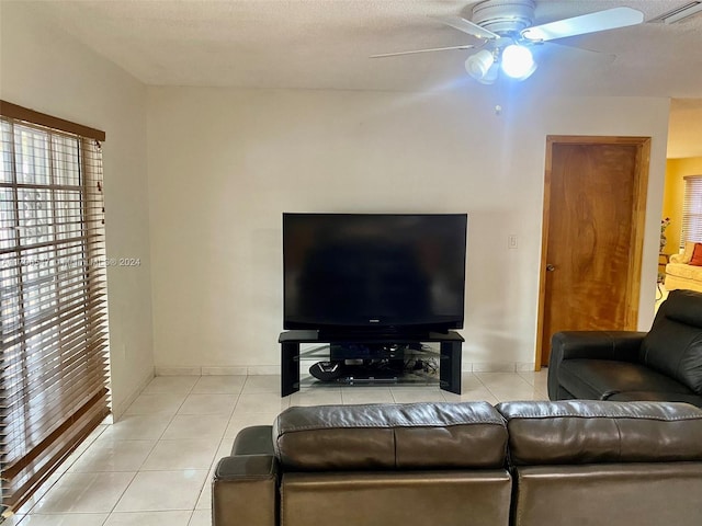 tiled living room with ceiling fan and a textured ceiling