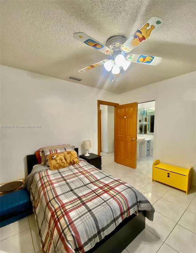 tiled bedroom with ceiling fan and a textured ceiling