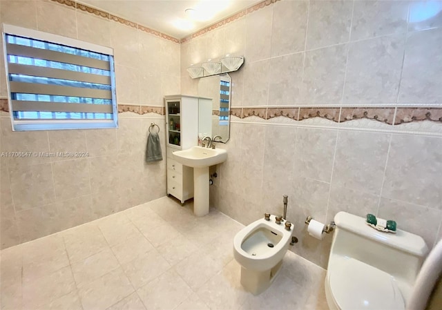 bathroom with tile patterned flooring, a bidet, tile walls, and toilet