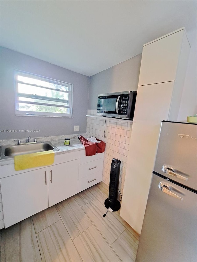 kitchen featuring white cabinetry, sink, and appliances with stainless steel finishes