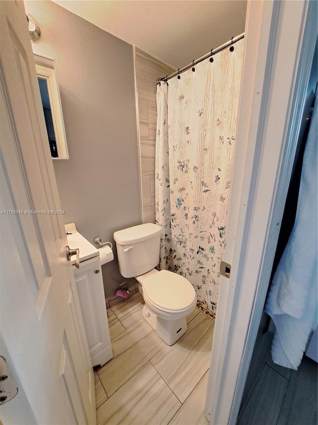 bathroom featuring vanity, toilet, and curtained shower