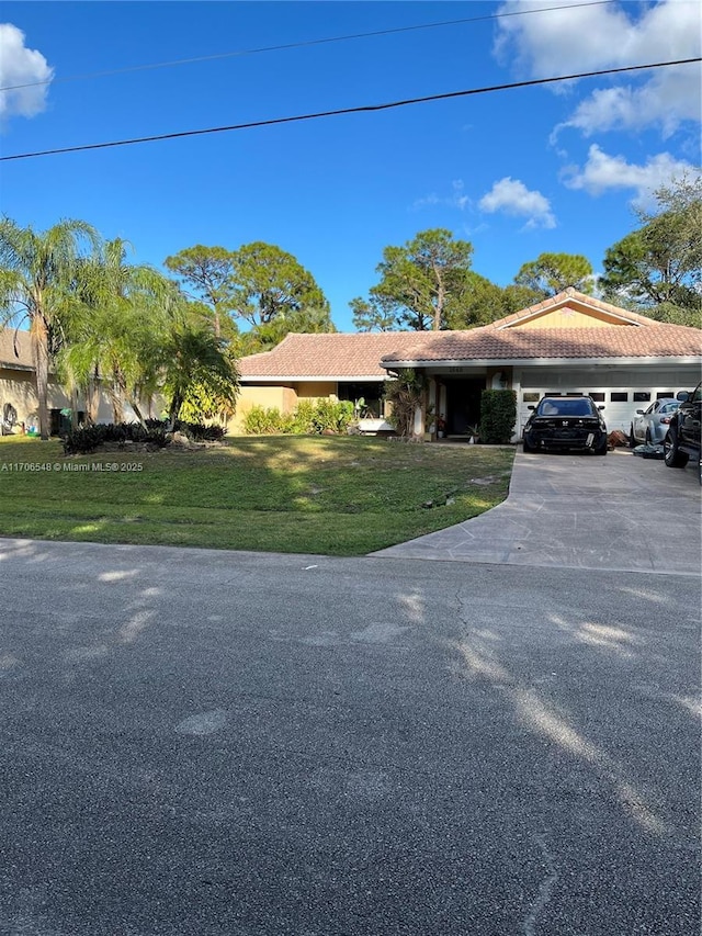 ranch-style house with a tiled roof, a front lawn, and concrete driveway