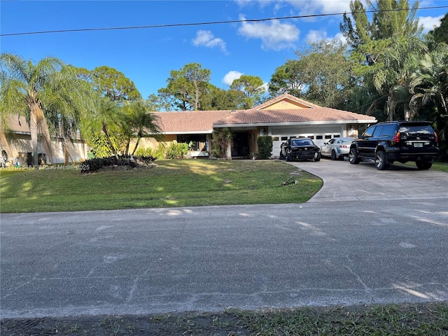 ranch-style house with a front lawn, a tiled roof, driveway, an attached garage, and stucco siding