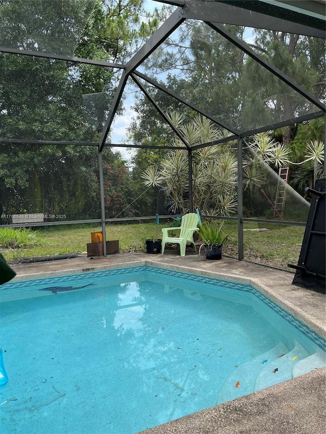 pool featuring glass enclosure and a patio area