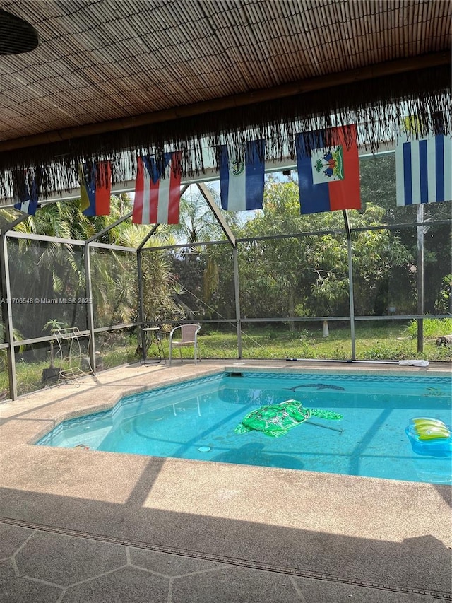 outdoor pool with a lanai and a patio