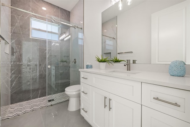 bathroom featuring vanity, toilet, and a shower with shower door