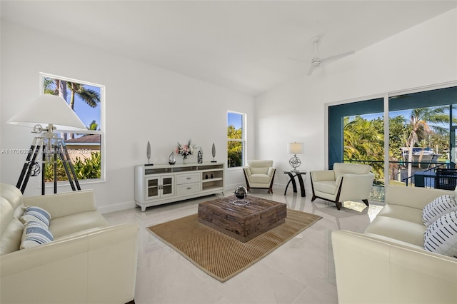 tiled living room featuring ceiling fan and vaulted ceiling