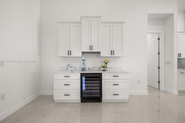 bar with white cabinetry and beverage cooler