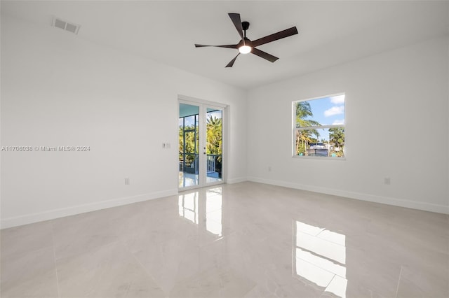 empty room with ceiling fan and a healthy amount of sunlight