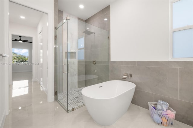 bathroom with ceiling fan, tile walls, and shower with separate bathtub