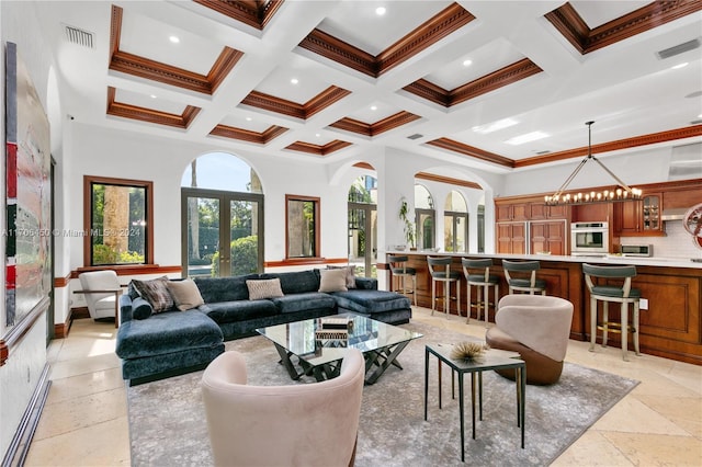 living room featuring coffered ceiling, beam ceiling, ornamental molding, and french doors